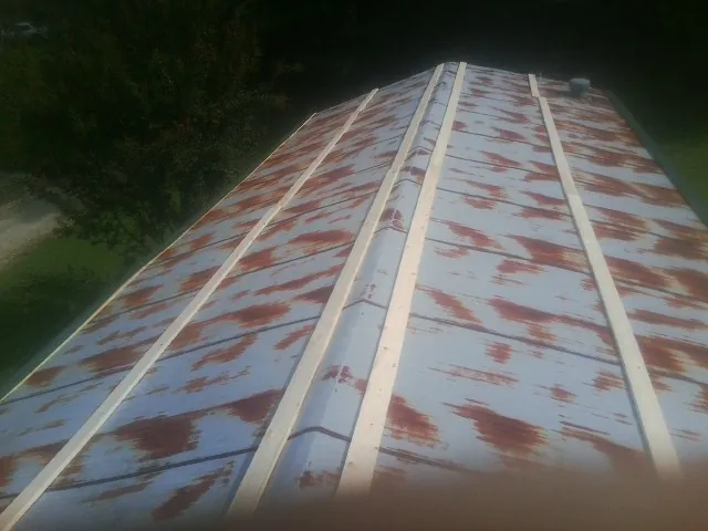 Rusted metal roof panels with new wood purlins before replacement — Storm Damage Roof Repair in Liberty Center by Roofing Brothers